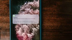 Seseorang sedang memegang smartphone dengan layar terkunci di tangan