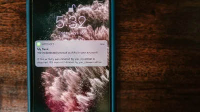 Seseorang sedang memegang smartphone dengan layar terkunci di tangan